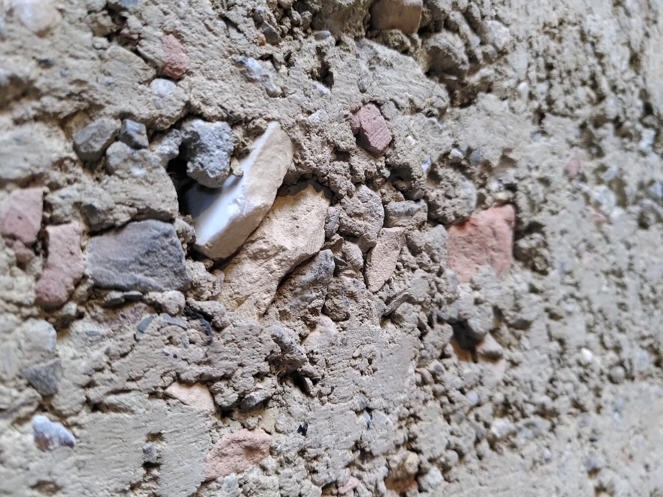 Lehmwand der Kapelle der Versöhnung in Berlin. Darin eingearbeitet sind Bruchstücke der 1985 gesprengten Versöhnungskirche.
